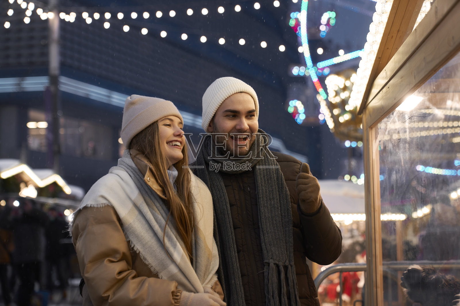 一对白种人夫妇晚上在圣诞市场上玩得很开心照片摄影图片