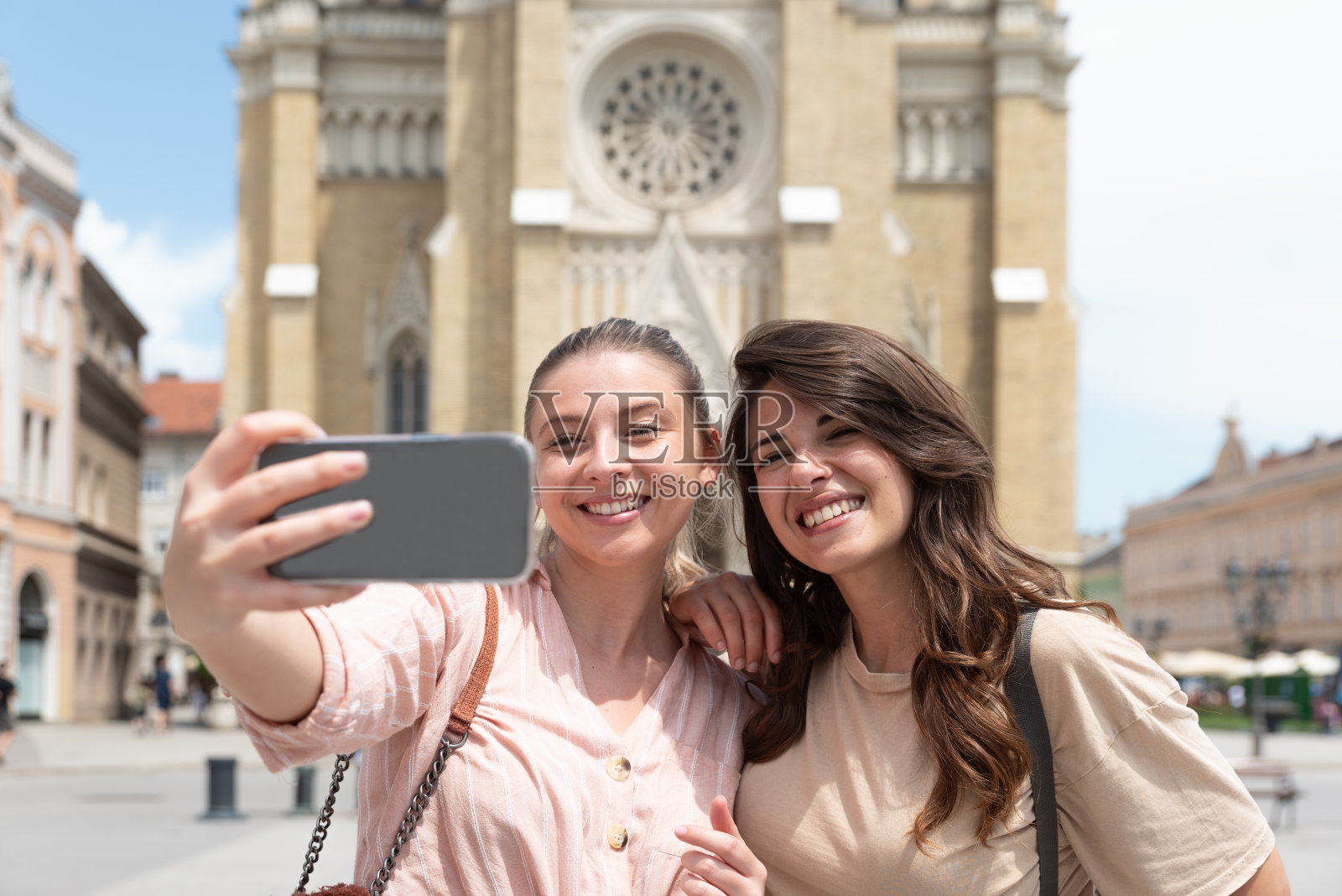两个兴奋快乐的时髦酷女人一起走在街上。高级时装模特在城市街道上摆姿势。快乐休闲,周末无忧无虑,浪漫假日,时尚时尚。照片摄影图片