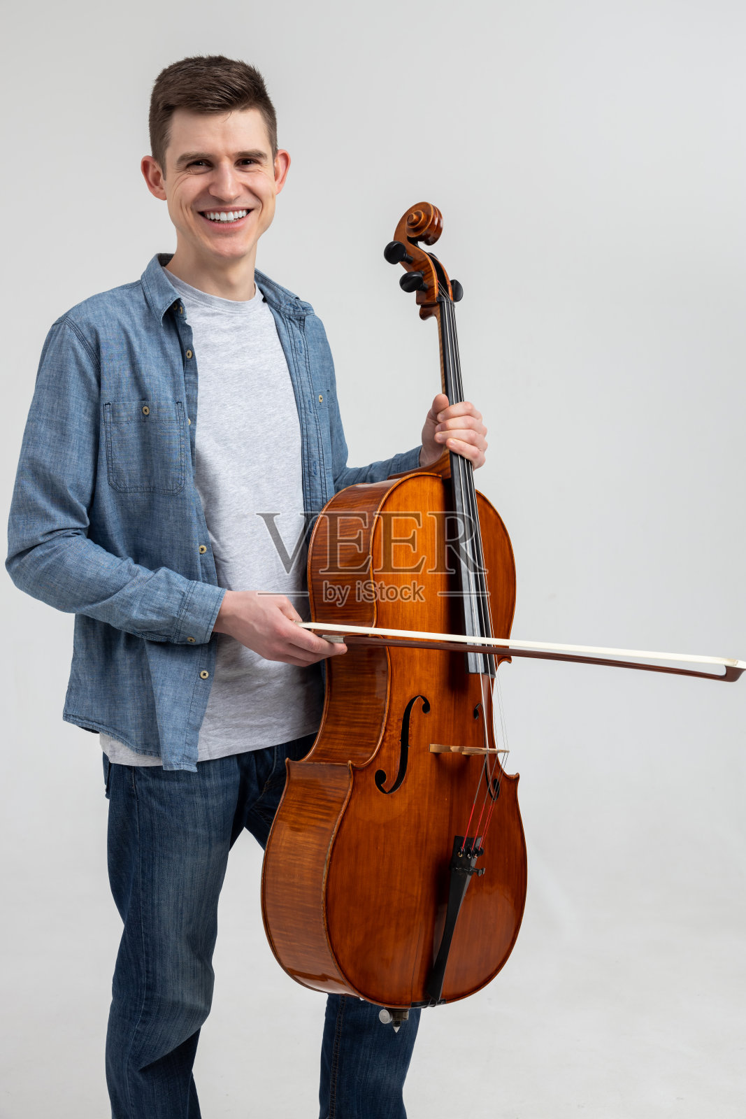 穿着休闲服的年轻人在演奏大提琴照片摄影图片