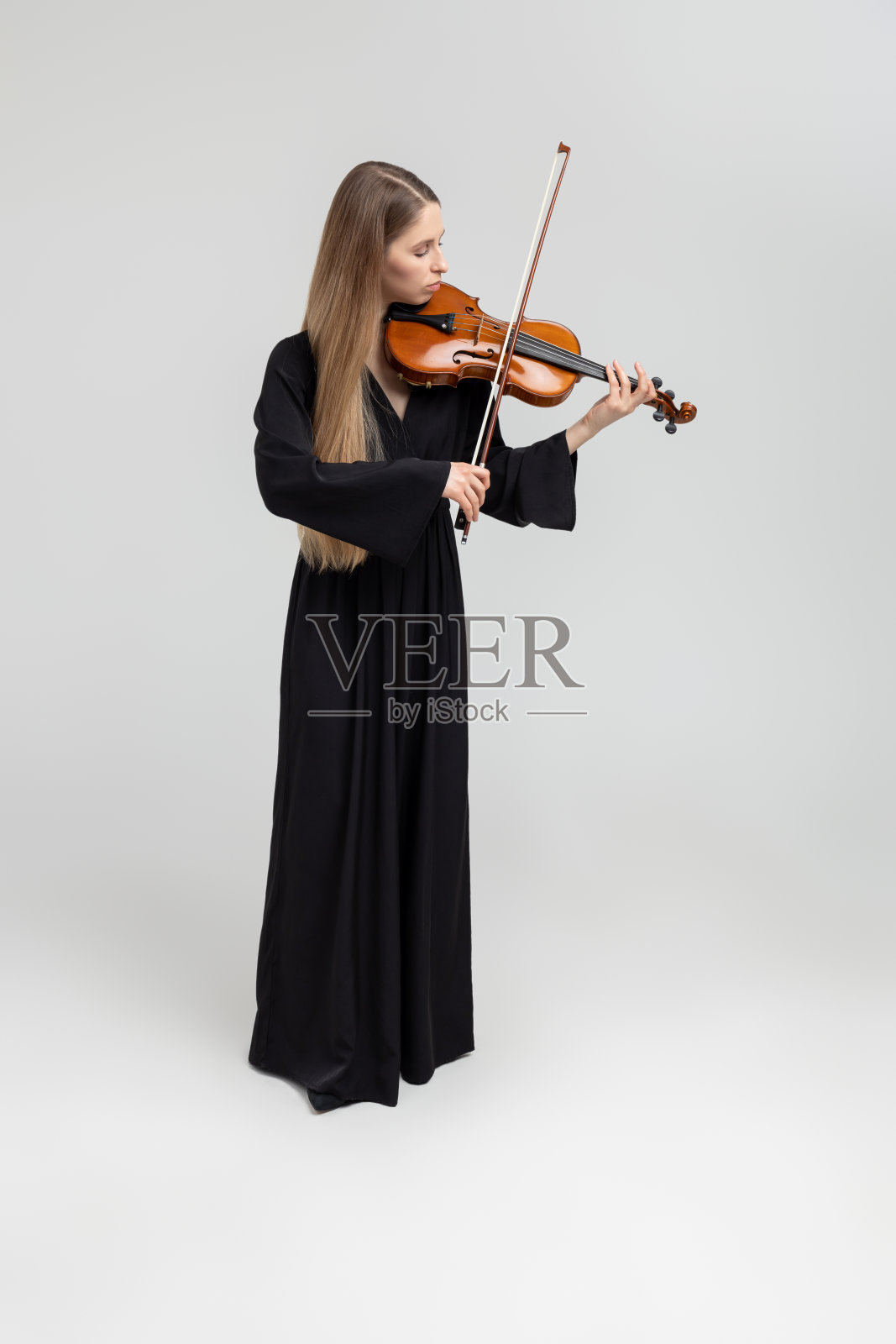 迷人的女音乐家拉小提琴的全长肖像照片摄影图片