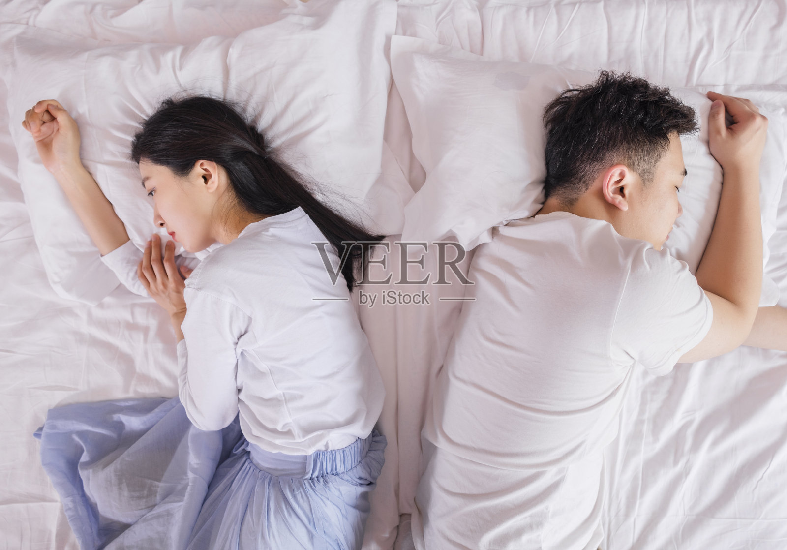 年轻夫妇在床上争吵照片摄影图片