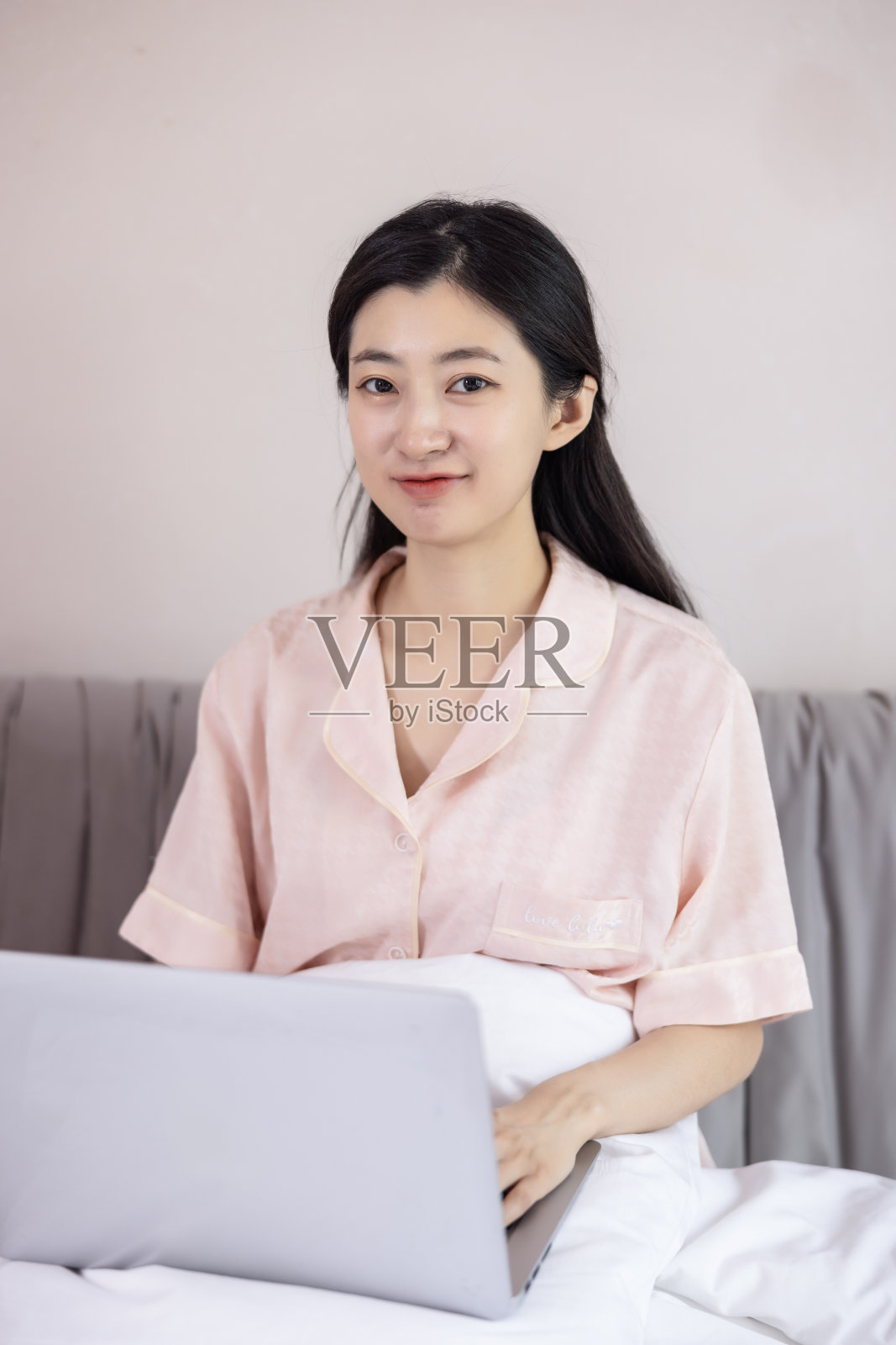 年轻女人坐在床上照片摄影图片