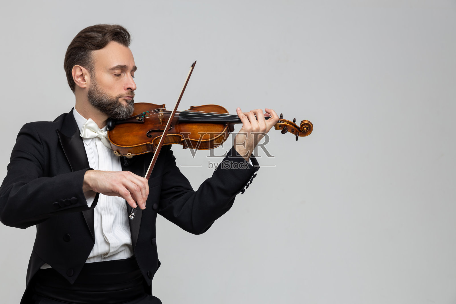 留胡子的音乐家在古典音乐会上演奏小提琴照片摄影图片