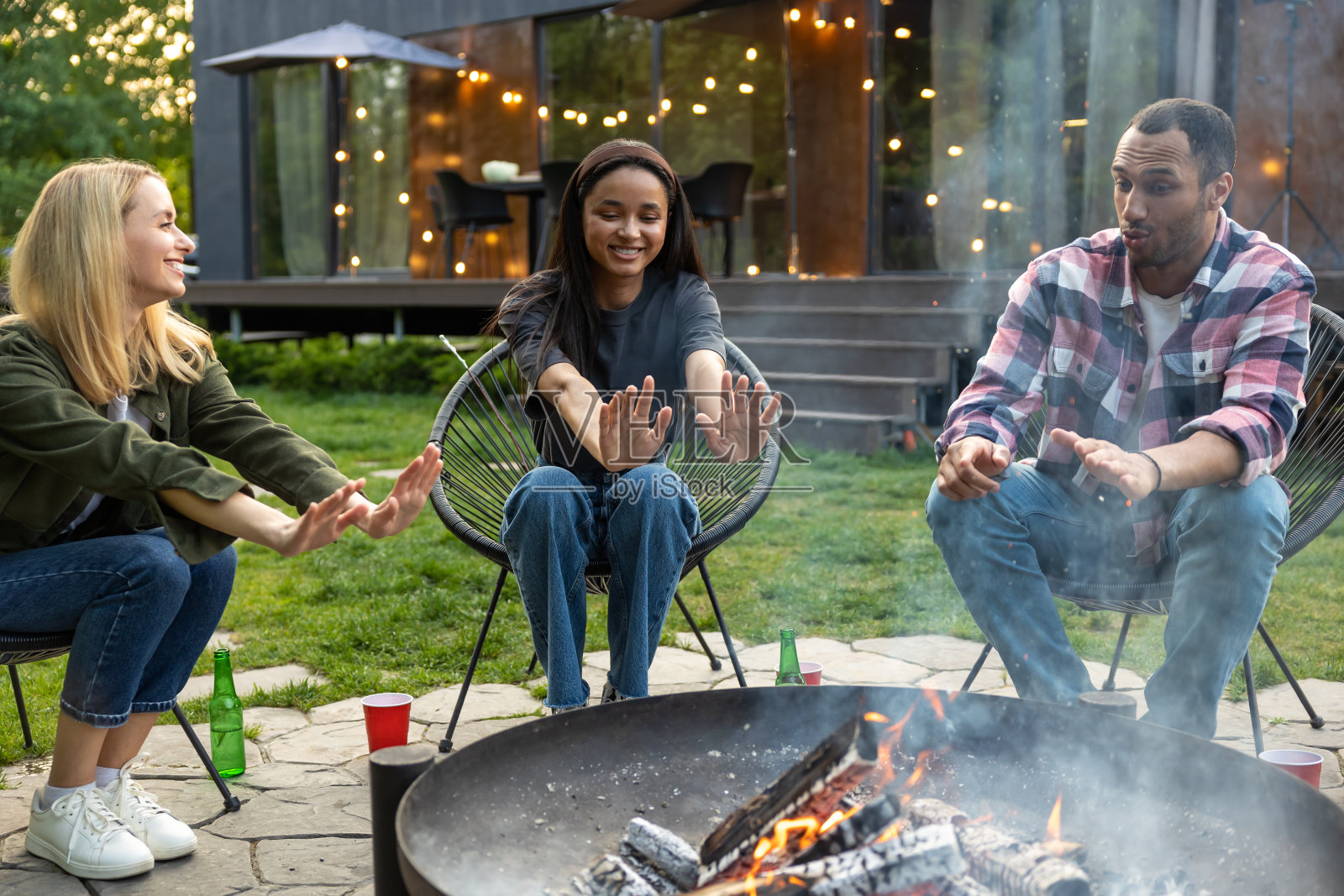 年轻快乐的朋友们在野餐,在烧烤派对上烧烤,享受乐趣和庆祝照片摄影图片