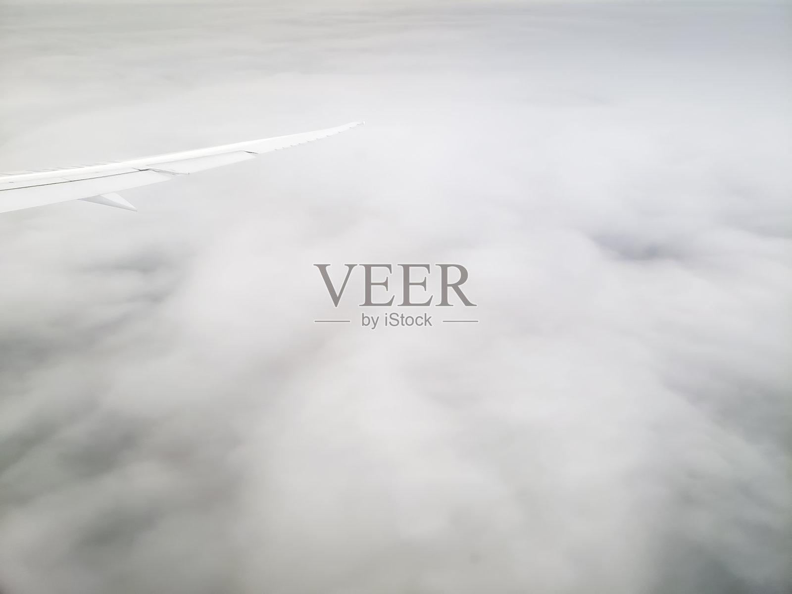 从客舱窗口看,飞机在云层上方飞行照片摄影图片