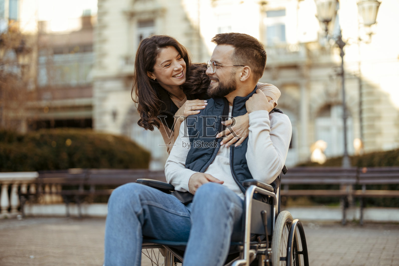 坐在轮椅上的残疾男子和他的妻子在户外照片摄影图片