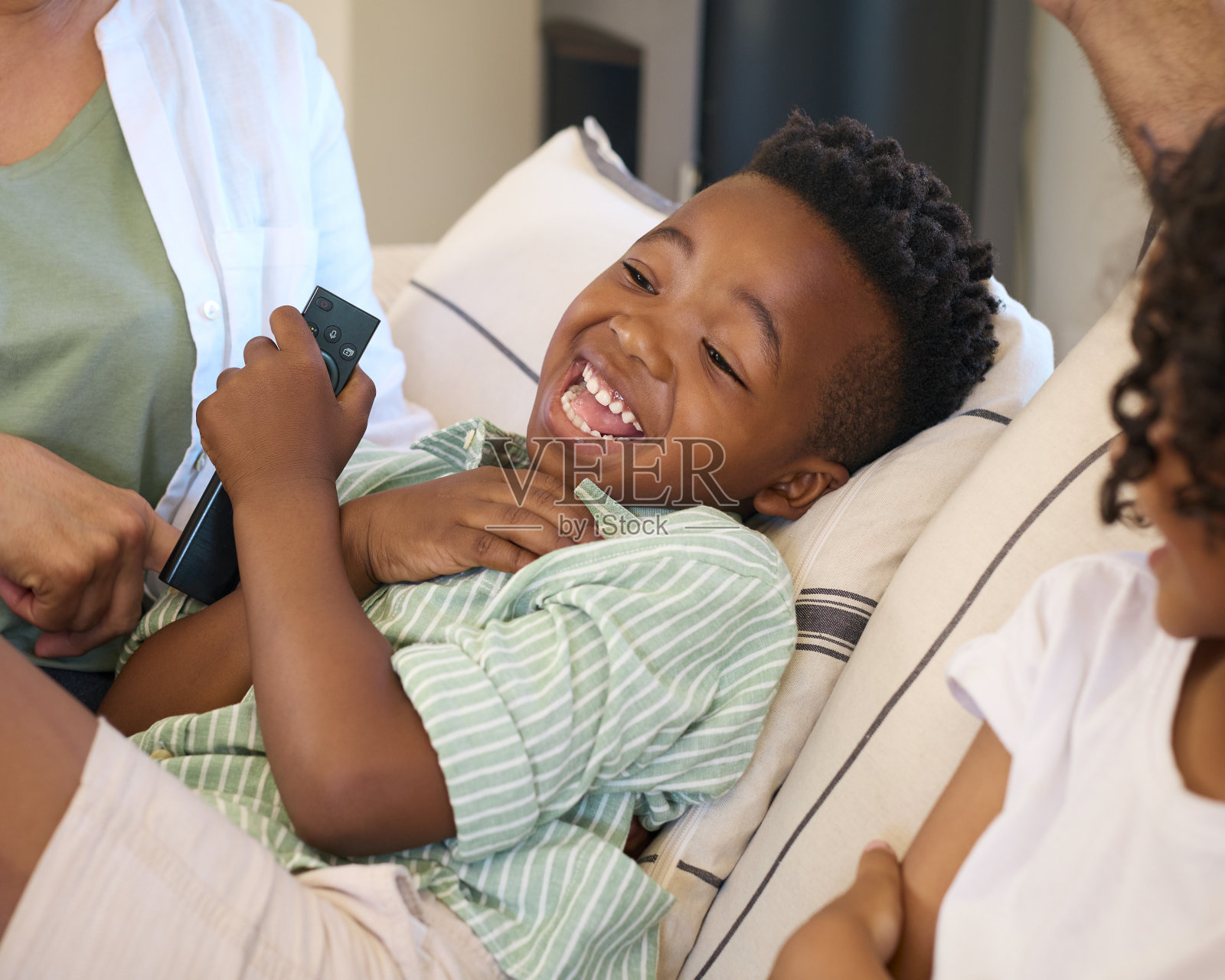 祖父母和孙子坐在家里的沙发上一起看电视照片摄影图片