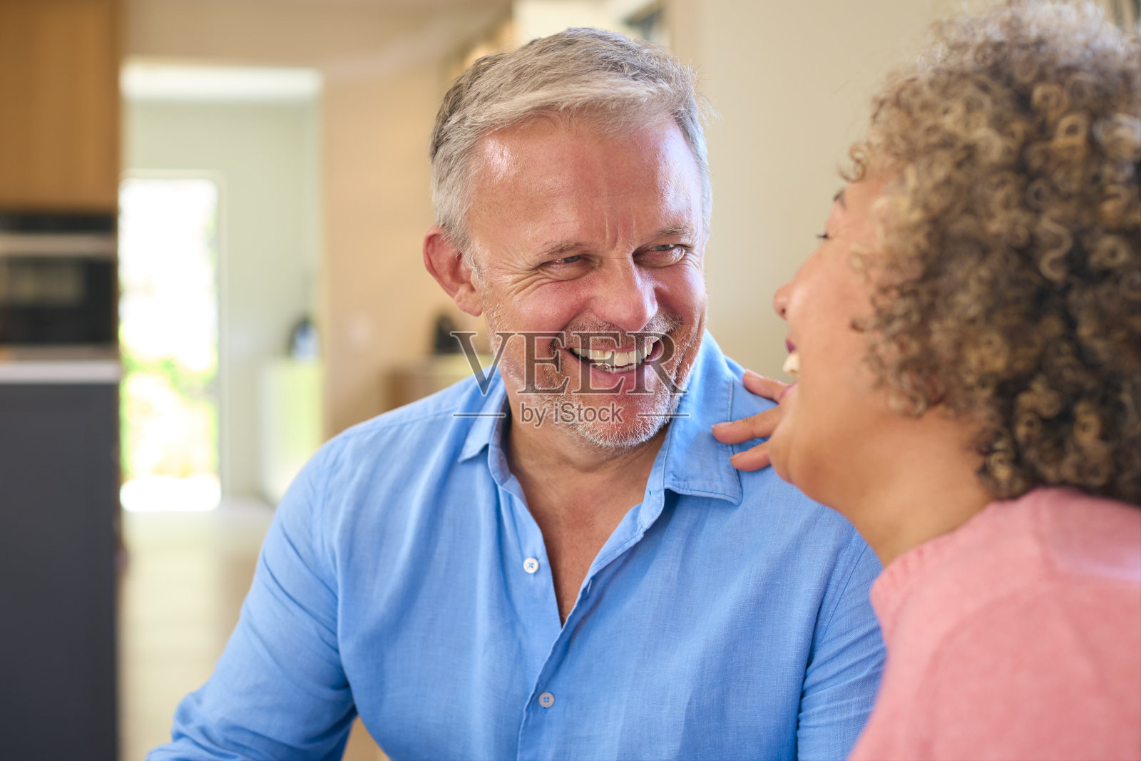 可爱的多种族成熟夫妇坐在家里的沙发上谈笑风生照片摄影图片