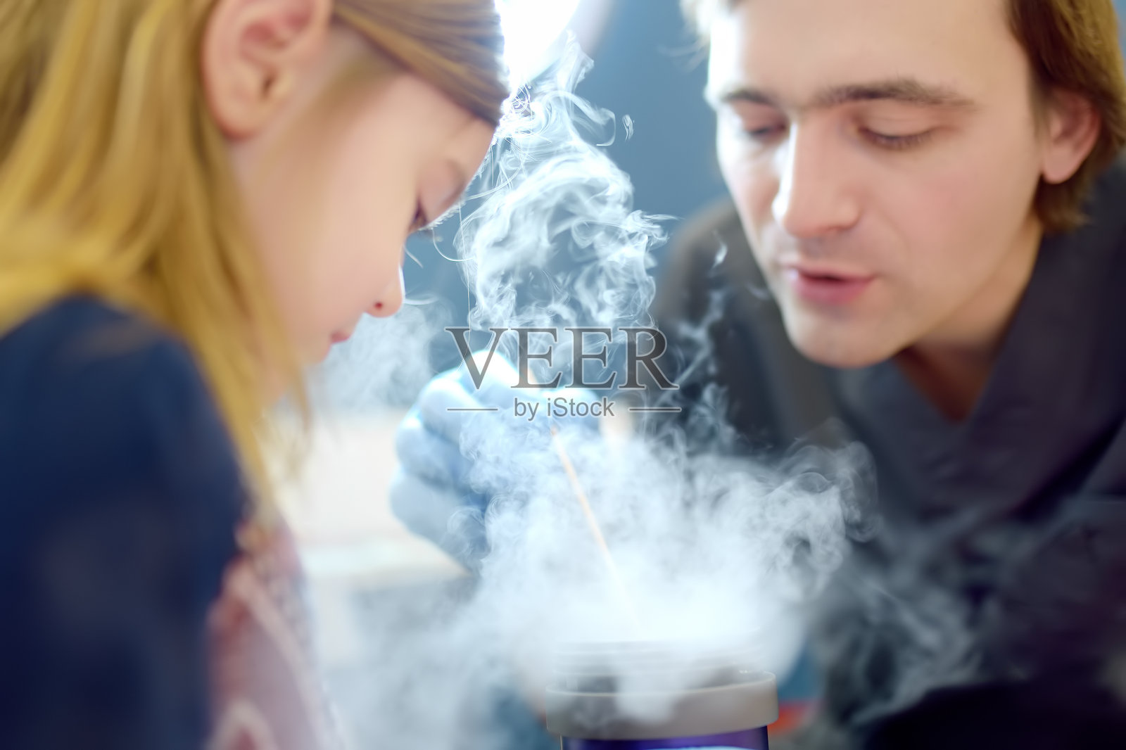 一位细心的医生正在检查小孩皮肤上的痣。皮肤科医生用液氮为可爱的学龄前女孩切除良性肿瘤。婴儿害怕治疗。照片摄影图片