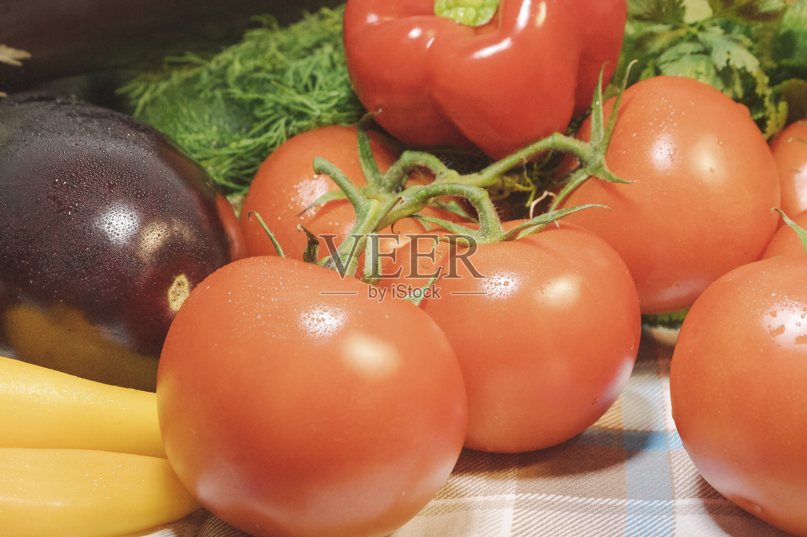 西红柿、茄子、西葫芦和黄辣椒的特写。在厨房的桌子上照片摄影图片