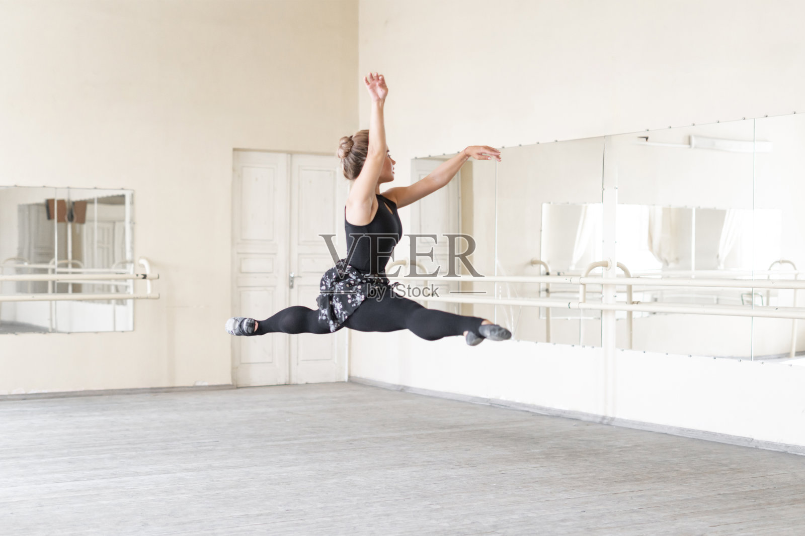 女芭蕾舞演员在舞蹈室里翩翩起舞,跳得又高又飞照片摄影图片