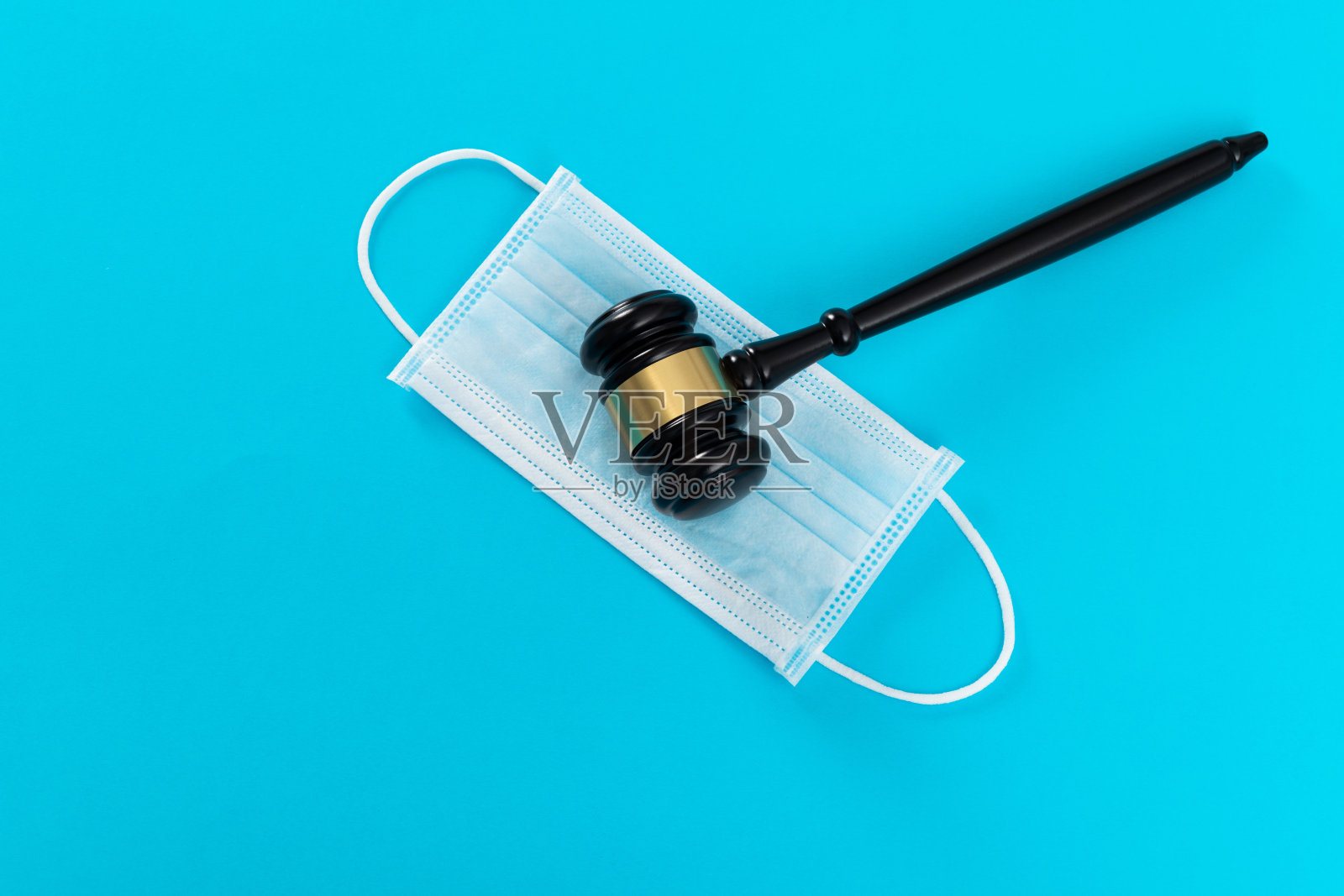 蓝色背景上的法槌和防护口罩照片摄影图片