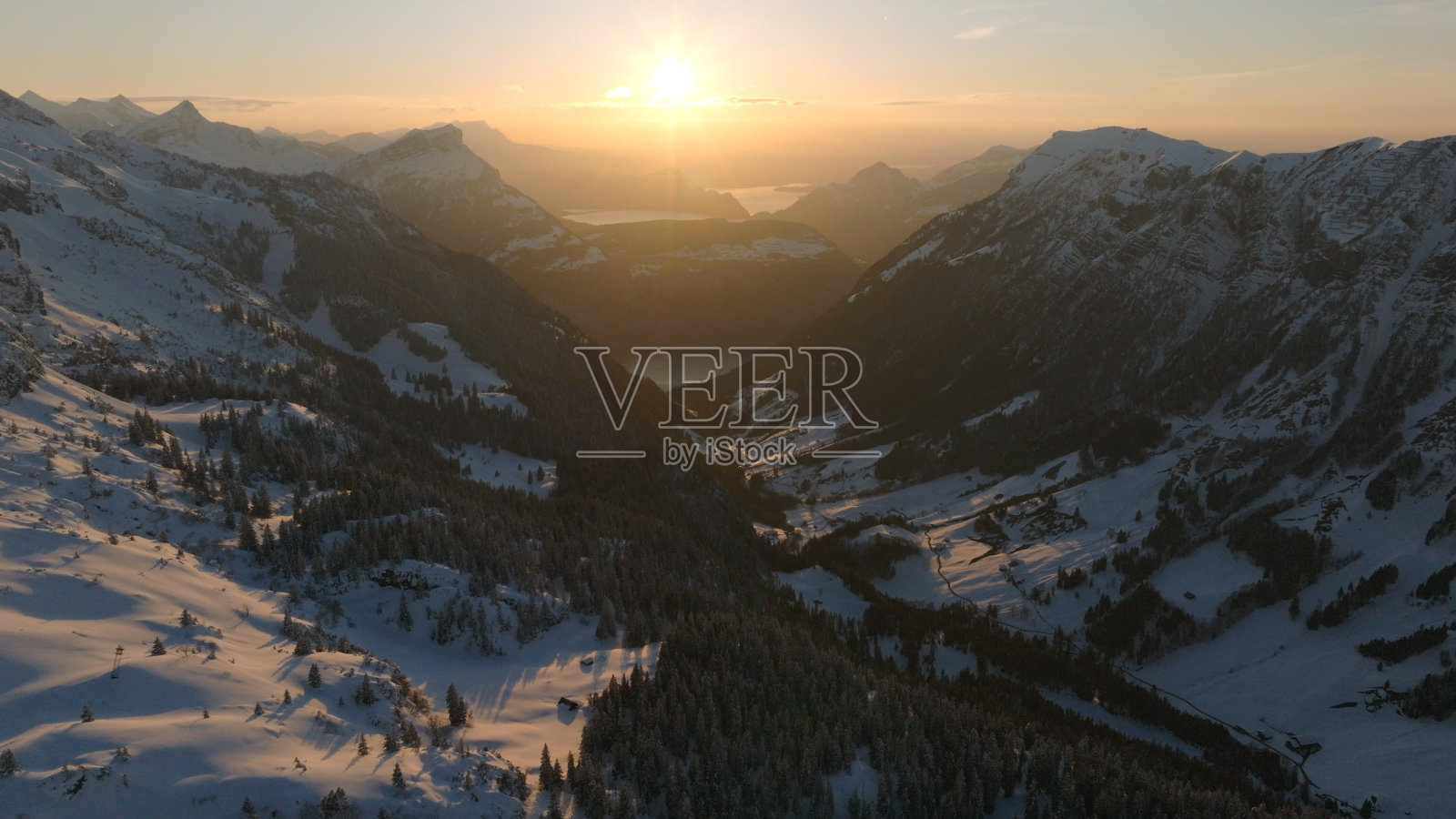 白雪皑皑的山脉和森林上的日出照片摄影图片