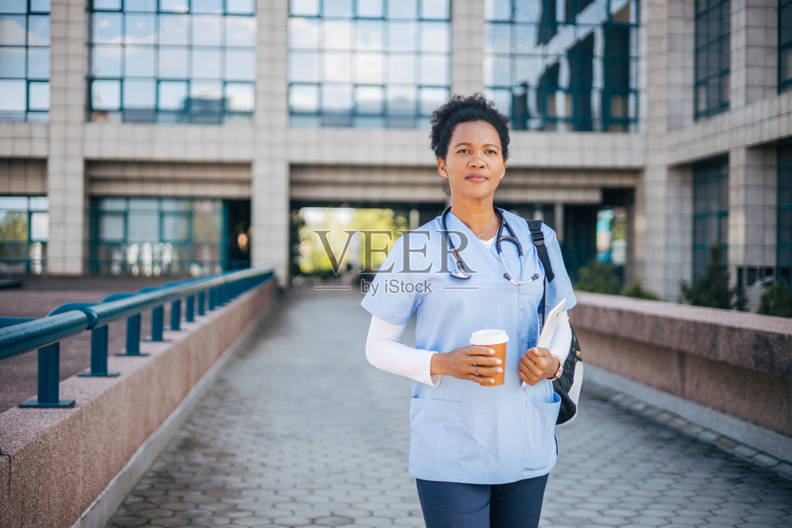 穿着制服的年轻护士在诊所前喝咖啡休息照片摄影图片