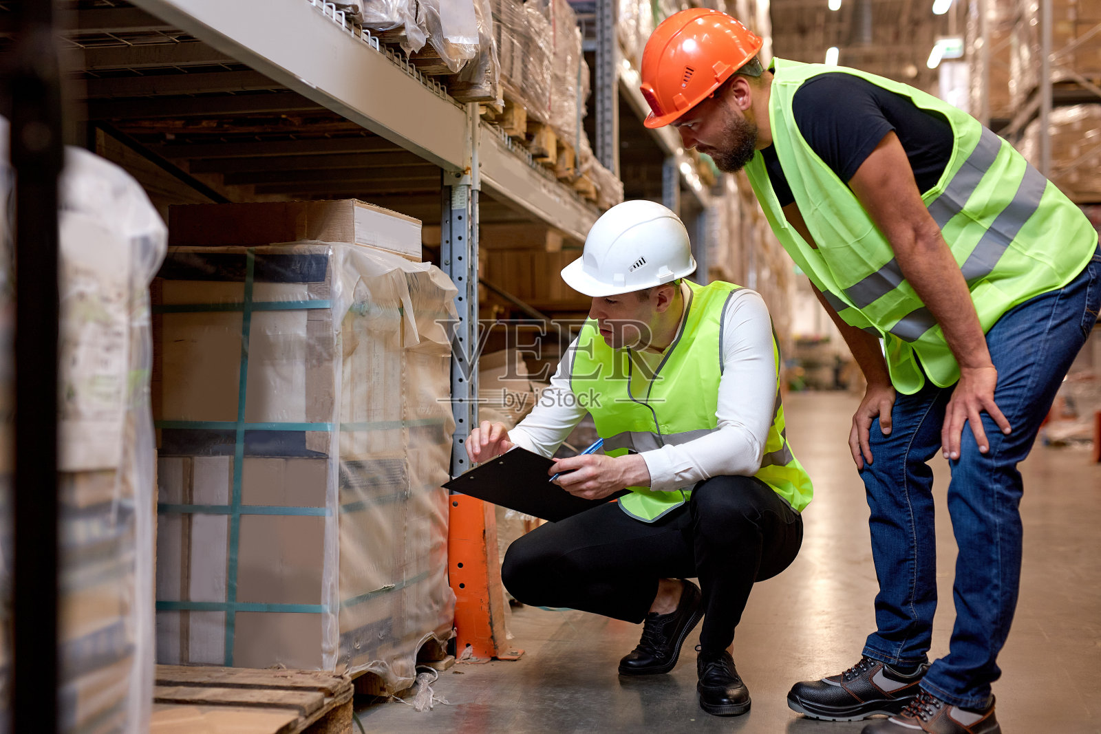 经理和主管在仓库盘点,穿着制服的男员工交谈照片摄影图片