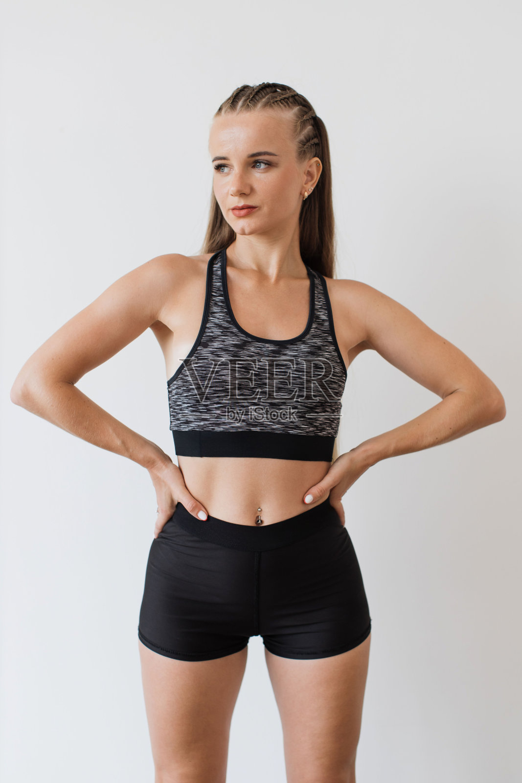 自信的年轻女子穿着健身服在室内摆姿势照片摄影图片