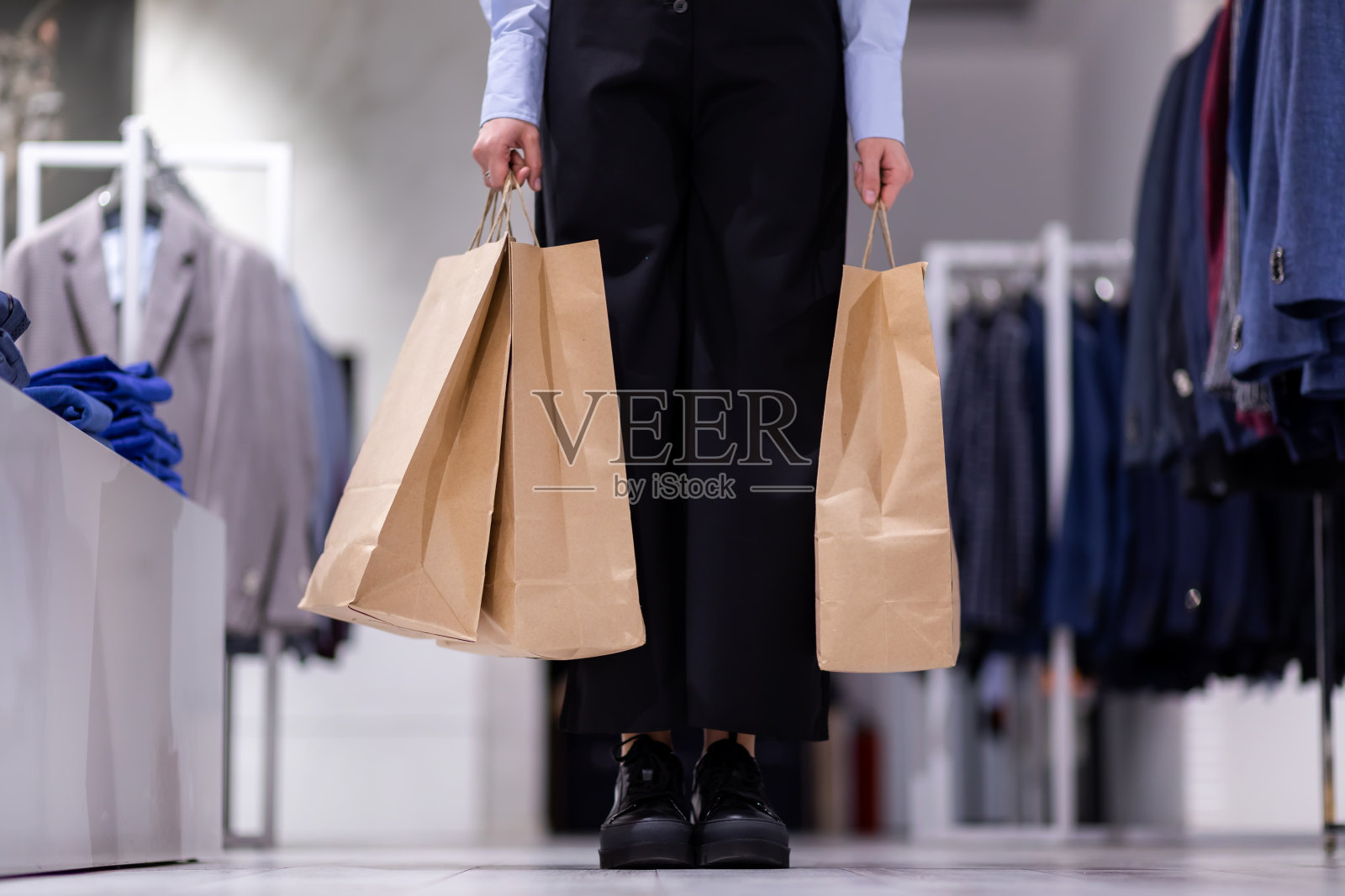 在商店里拿着购物袋的漂亮女人的手。照片摄影图片