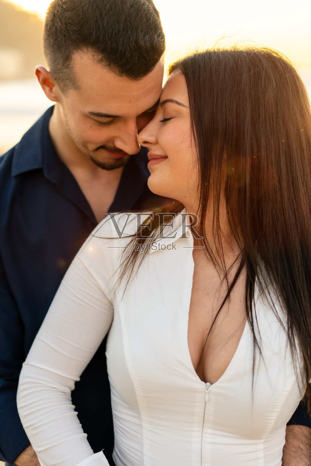 一对浪漫的夫妇在日落的海滩上的特写照片摄影图片