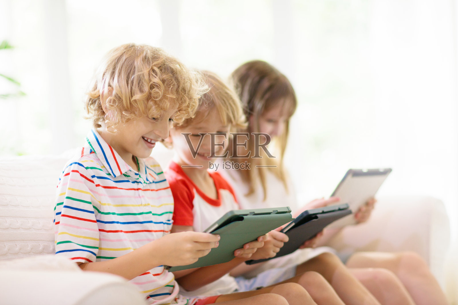 孩子们有手机。孩子有平板电脑照片摄影图片