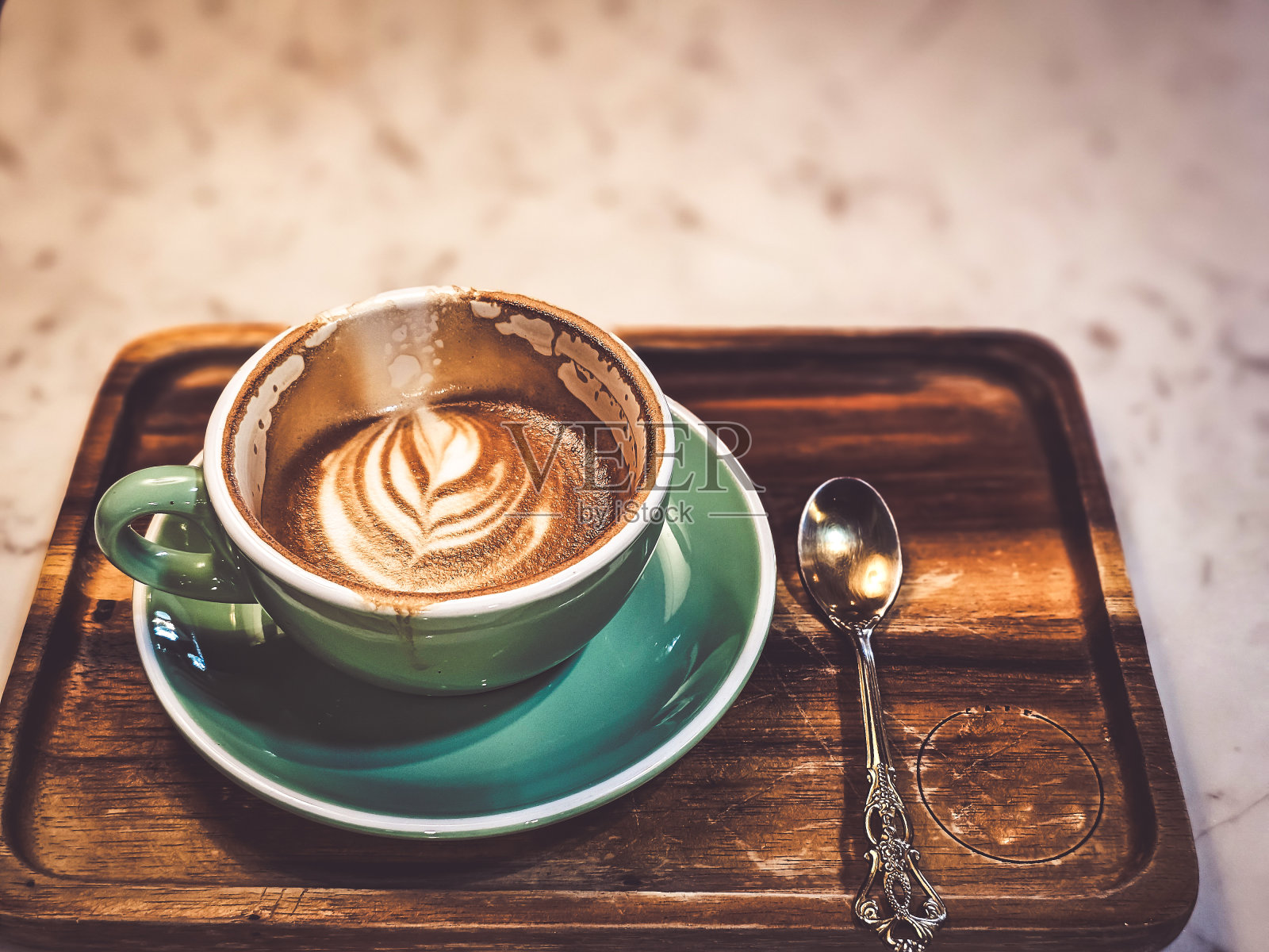 一杯热卡布奇诺咖啡,放在桌子上,营造温暖的气氛。有文字的空间。照片摄影图片