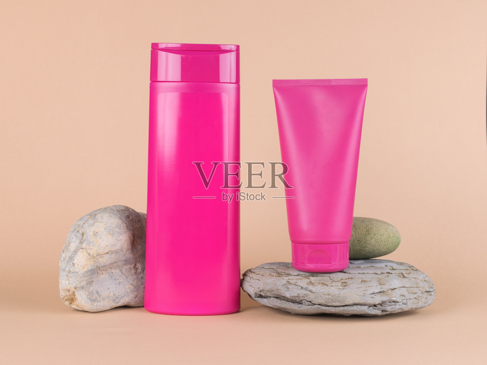 两管深红色的石头在米色的背景。照片摄影图片