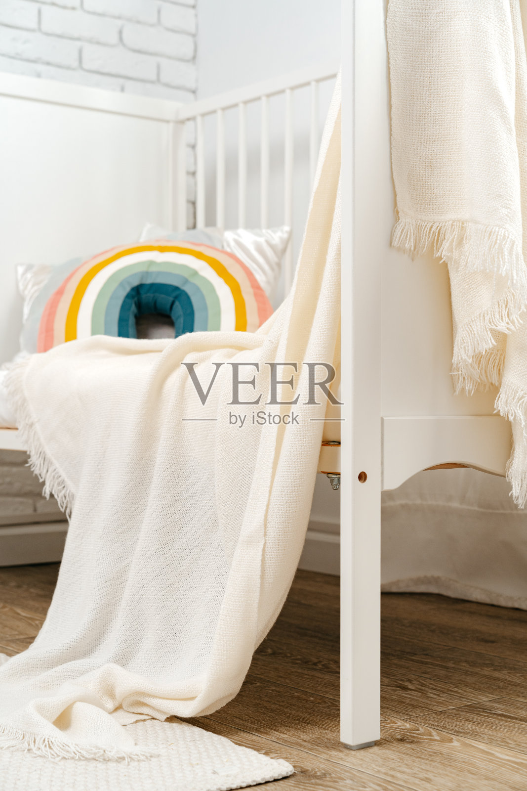 儿童房内部配有舒适的床和彩虹枕头照片摄影图片