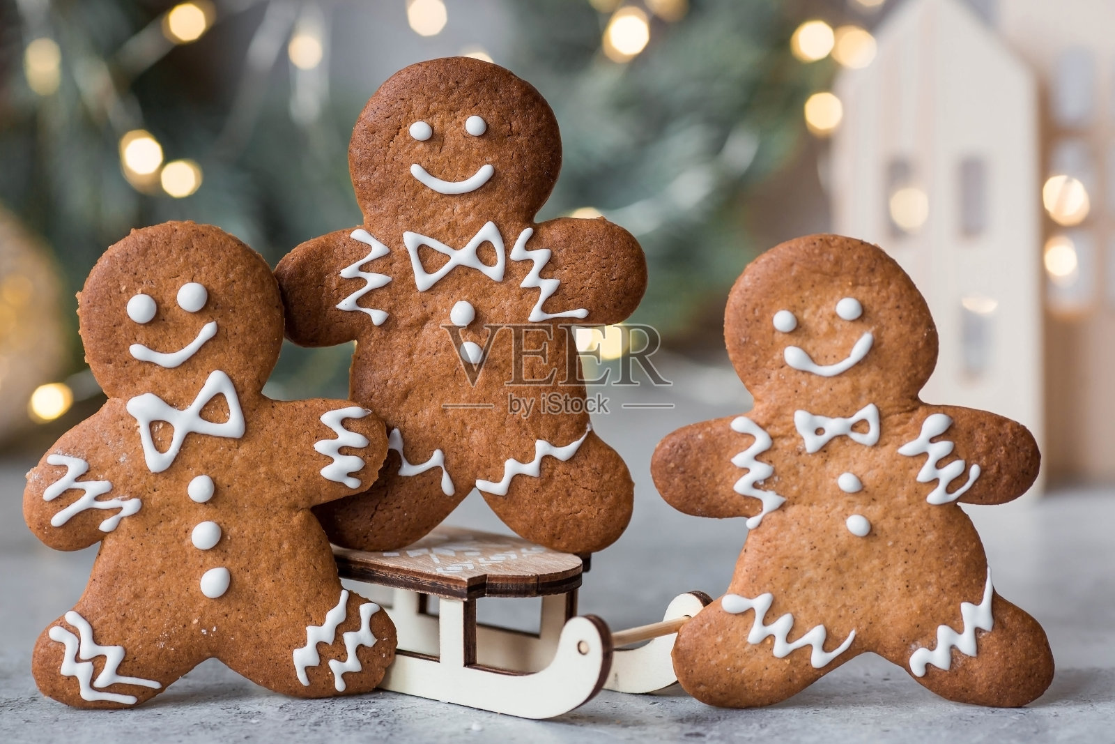自制的姜饼圣诞饼干,糖粉。美味的姜饼饼干的背景散景的圣诞树灯。新鲜出炉的圣诞姜饼饼干。照片摄影图片