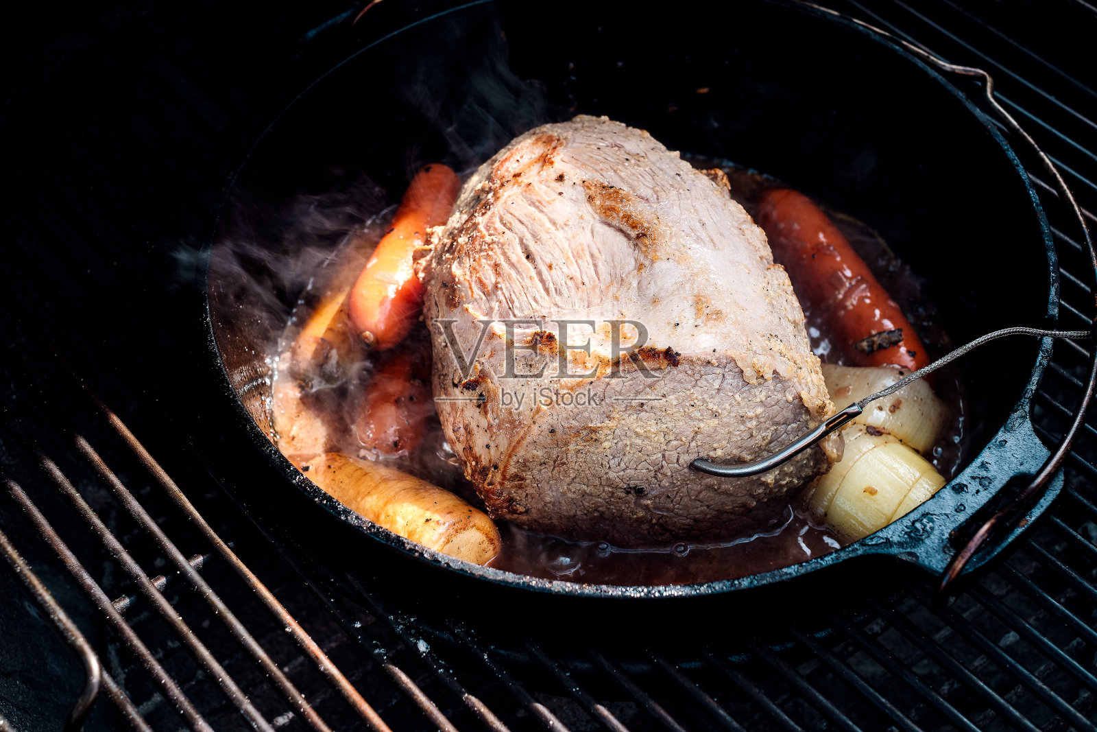 荷兰烤箱烤牛肉,胡萝卜和洋葱照片摄影图片