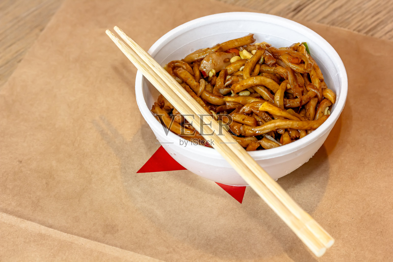 经典的亚洲街头小吃-乌冬炒面,猪肉,糖醋汁蔬菜,装在黑色的盘子里。白色背景照片摄影图片