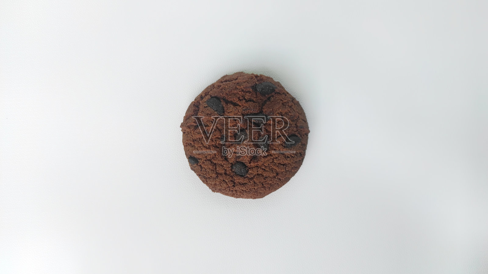 白色背景上点缀着巧克力片的巧克力饼干照片摄影图片