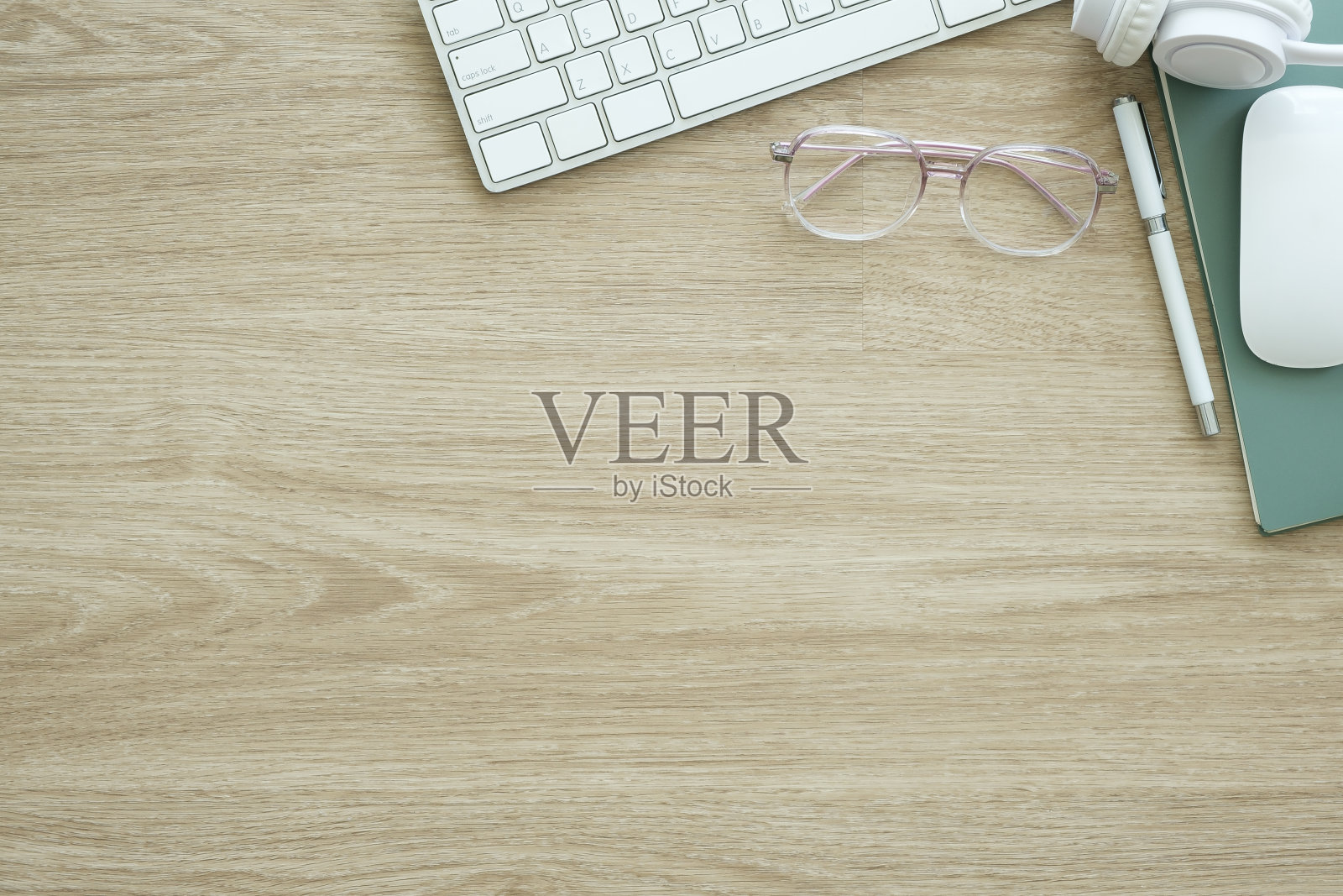 键盘,咖啡杯和文具在木制工作台上的俯视图。照片摄影图片