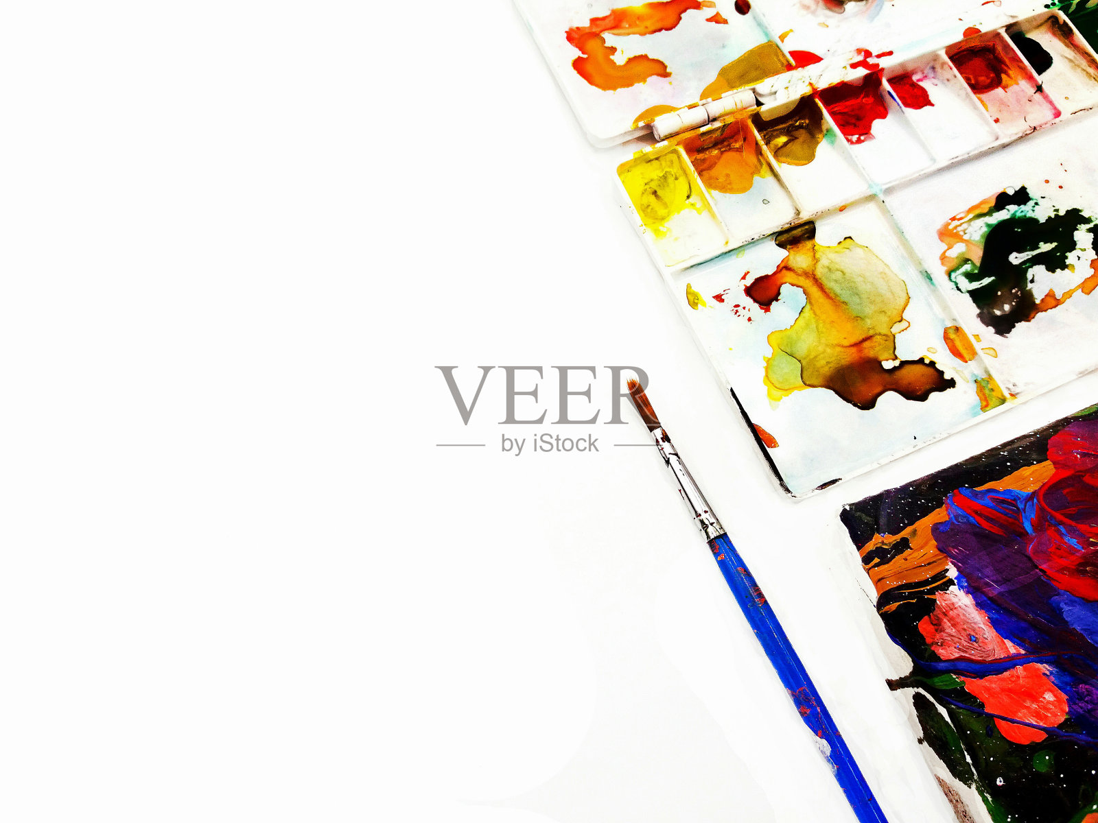 蓝色的画笔和白色的调色板被染成水彩孤立在白色的背景。艺术家工具和丰富多彩的背景概念照片摄影图片