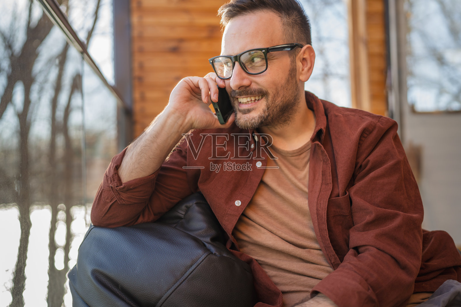 一幅成年男子坐在阳台上打电话的画像照片摄影图片