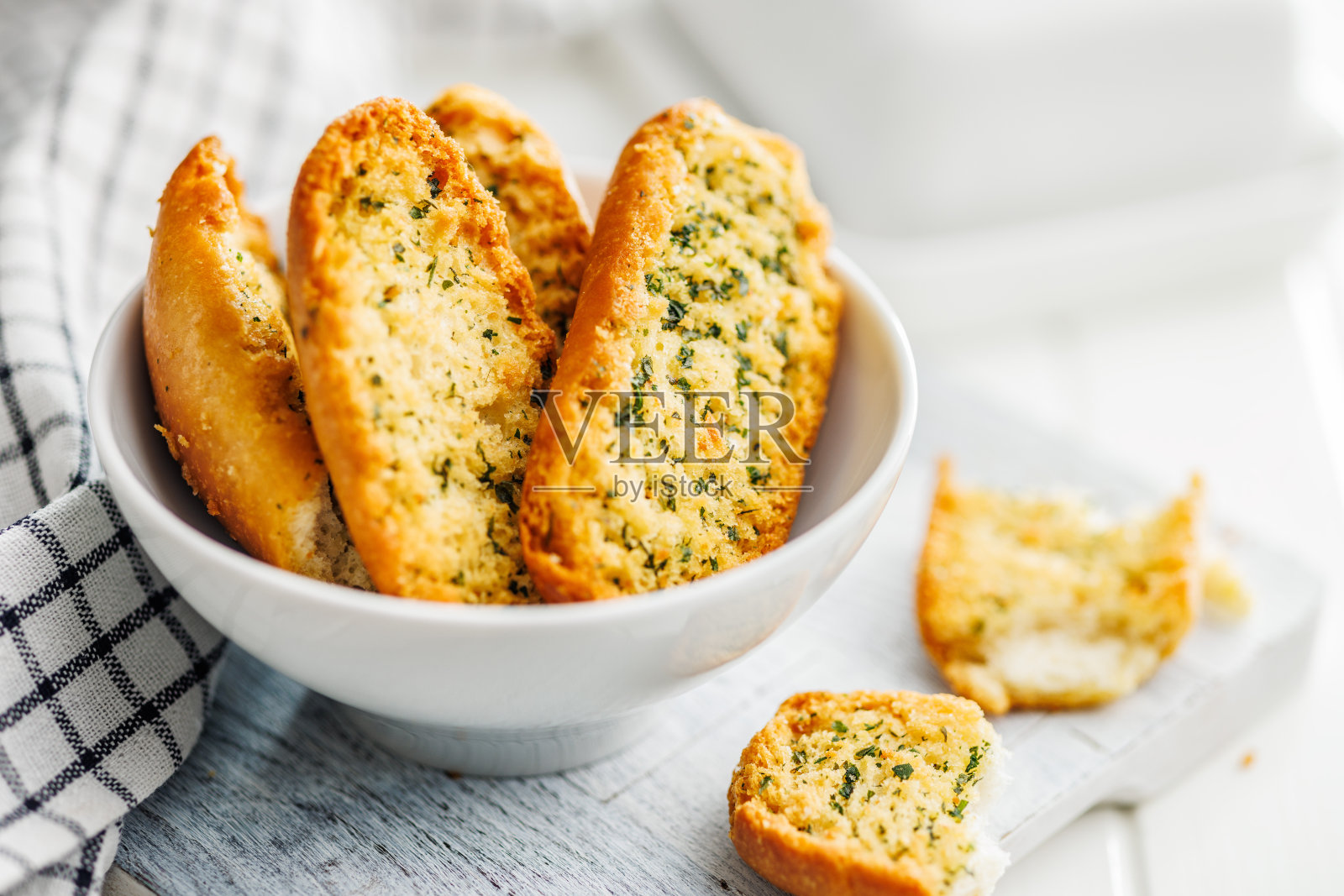 碗里的蒜香脆面包片配上香草。照片摄影图片