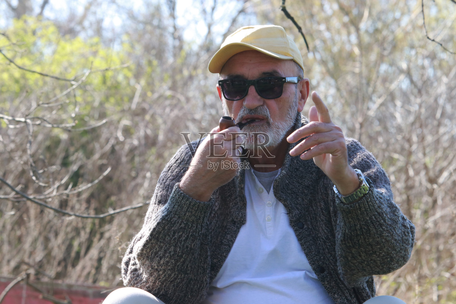 戴墨镜的老人在大自然中抽烟照片摄影图片