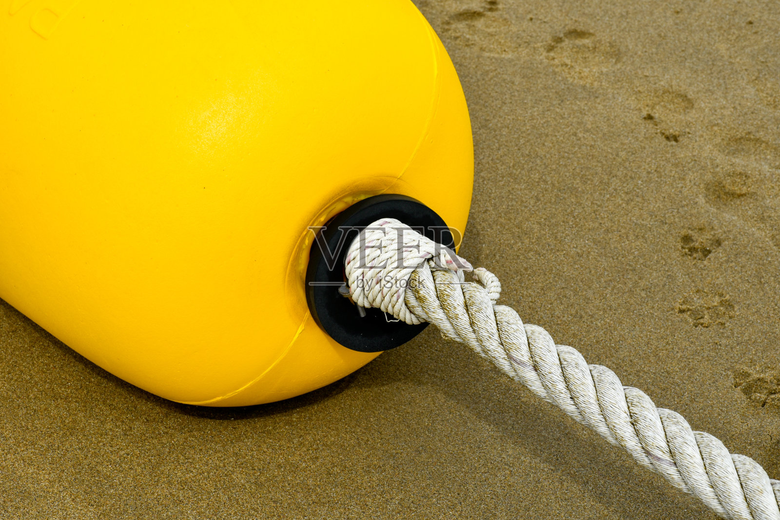 (特写)在沙滩上拴着绳子的黄色浮标被用来保护海洋或沙滩上的安全区。照片摄影图片