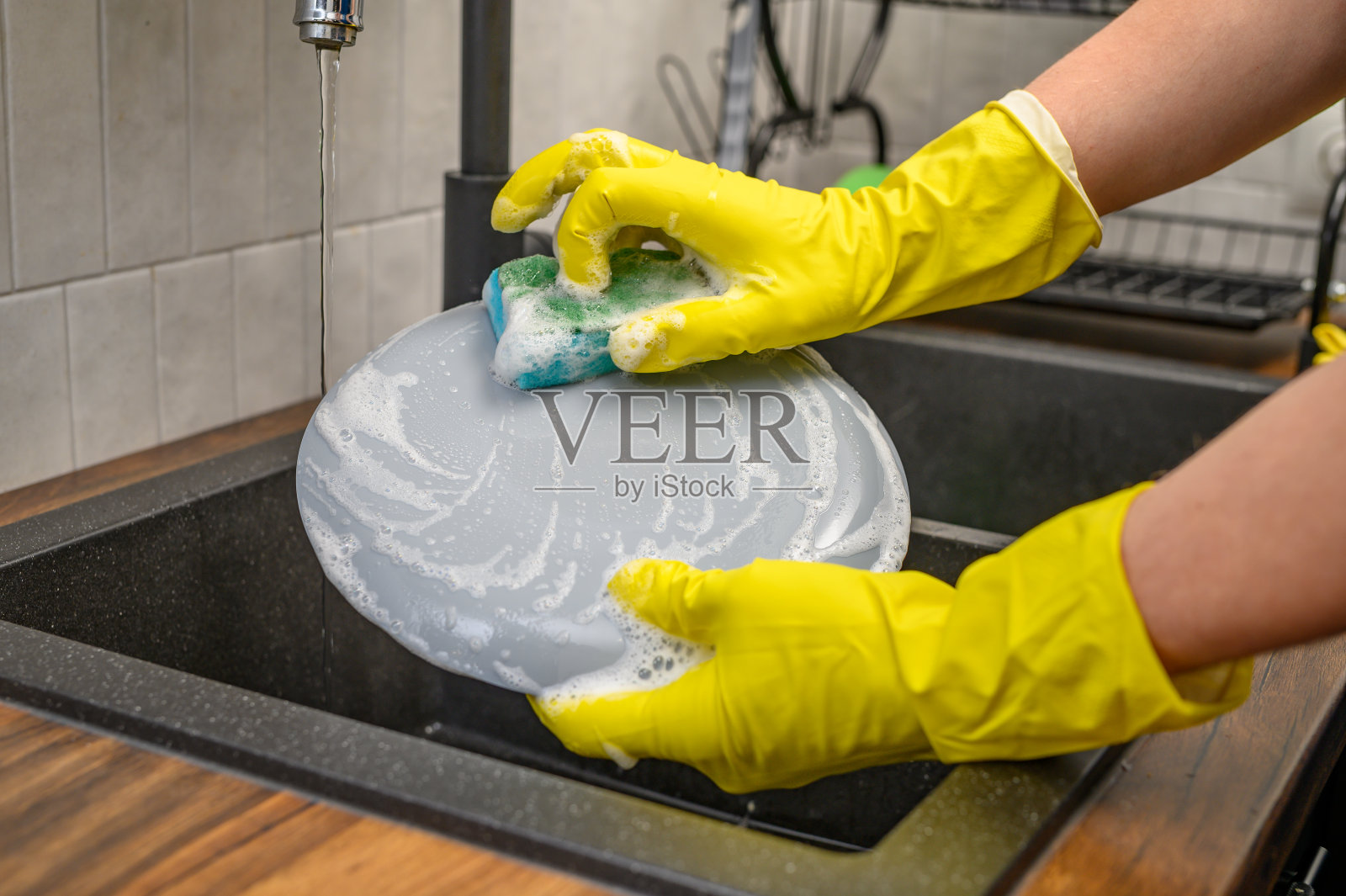 在家里用洗手池近距离洗手,泡沫洗洁精从盘子里流出照片摄影图片