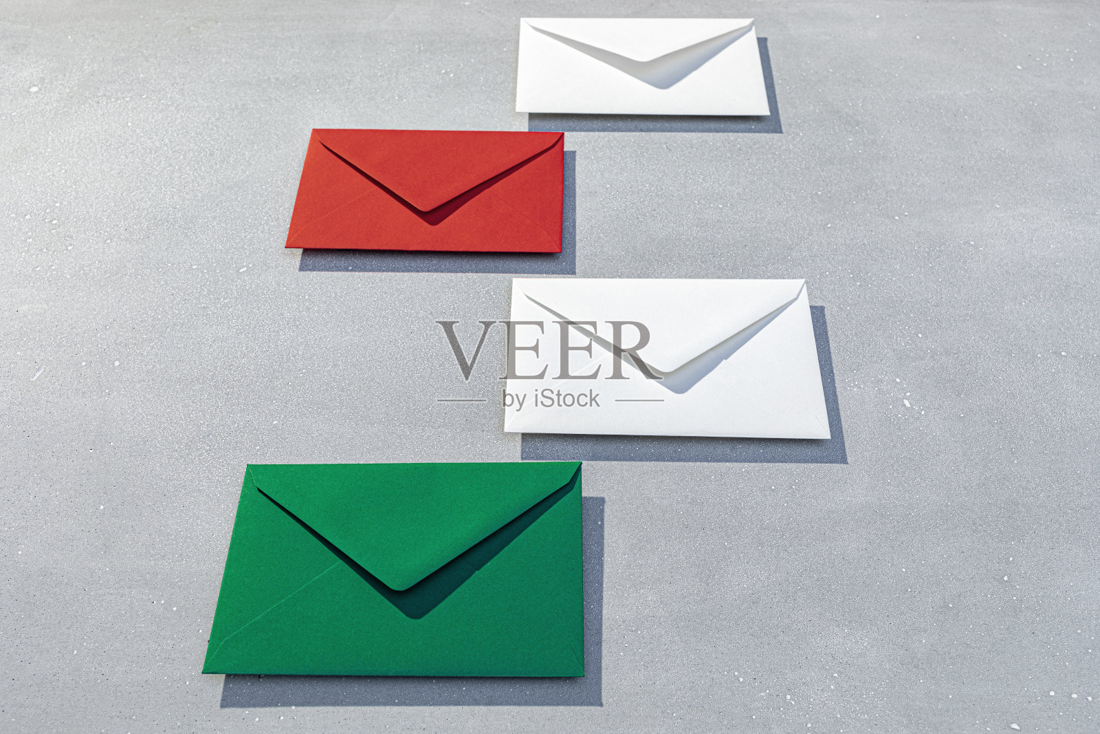 灰色的表面上摆放着各式各样的红白信封照片摄影图片