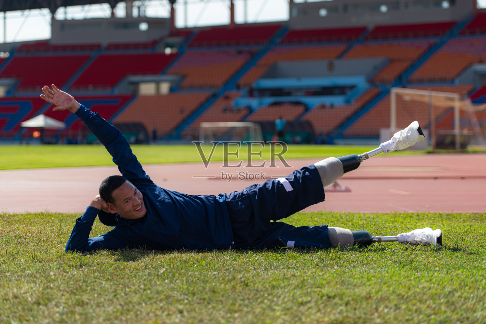 训练间歇,残疾运动员在体育场休息。照片摄影图片