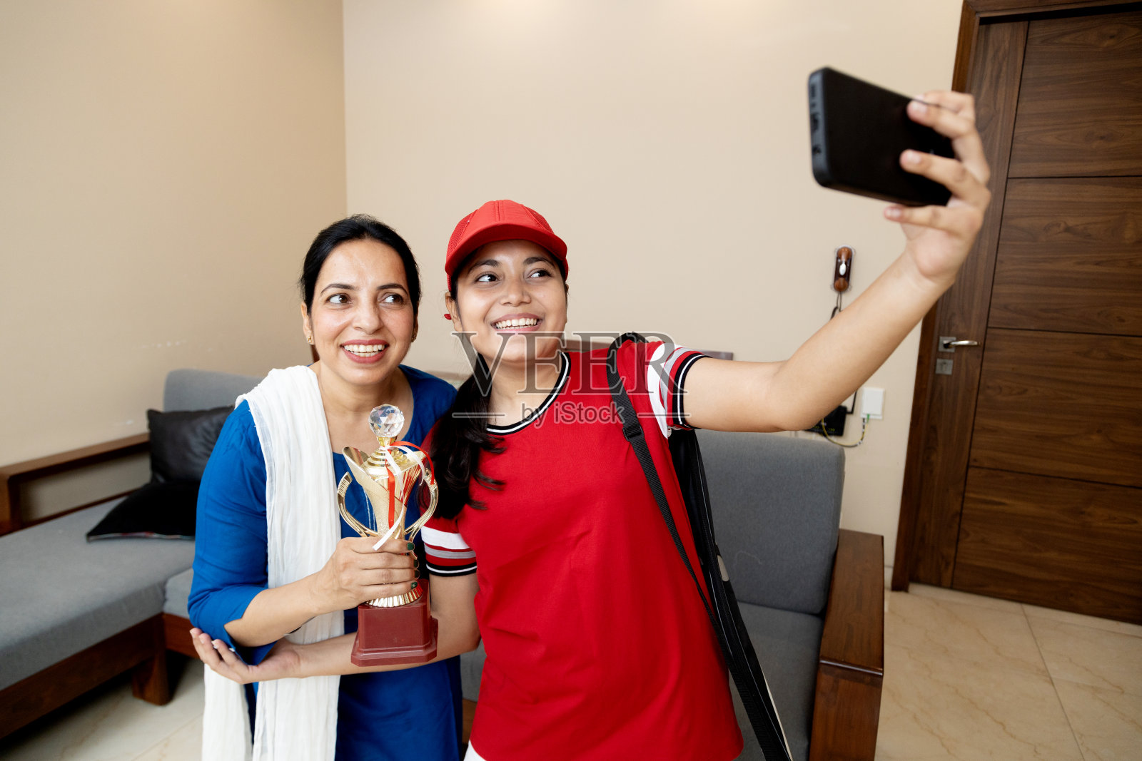 欣喜若狂的印度母女与获奖奖杯自拍照片摄影图片