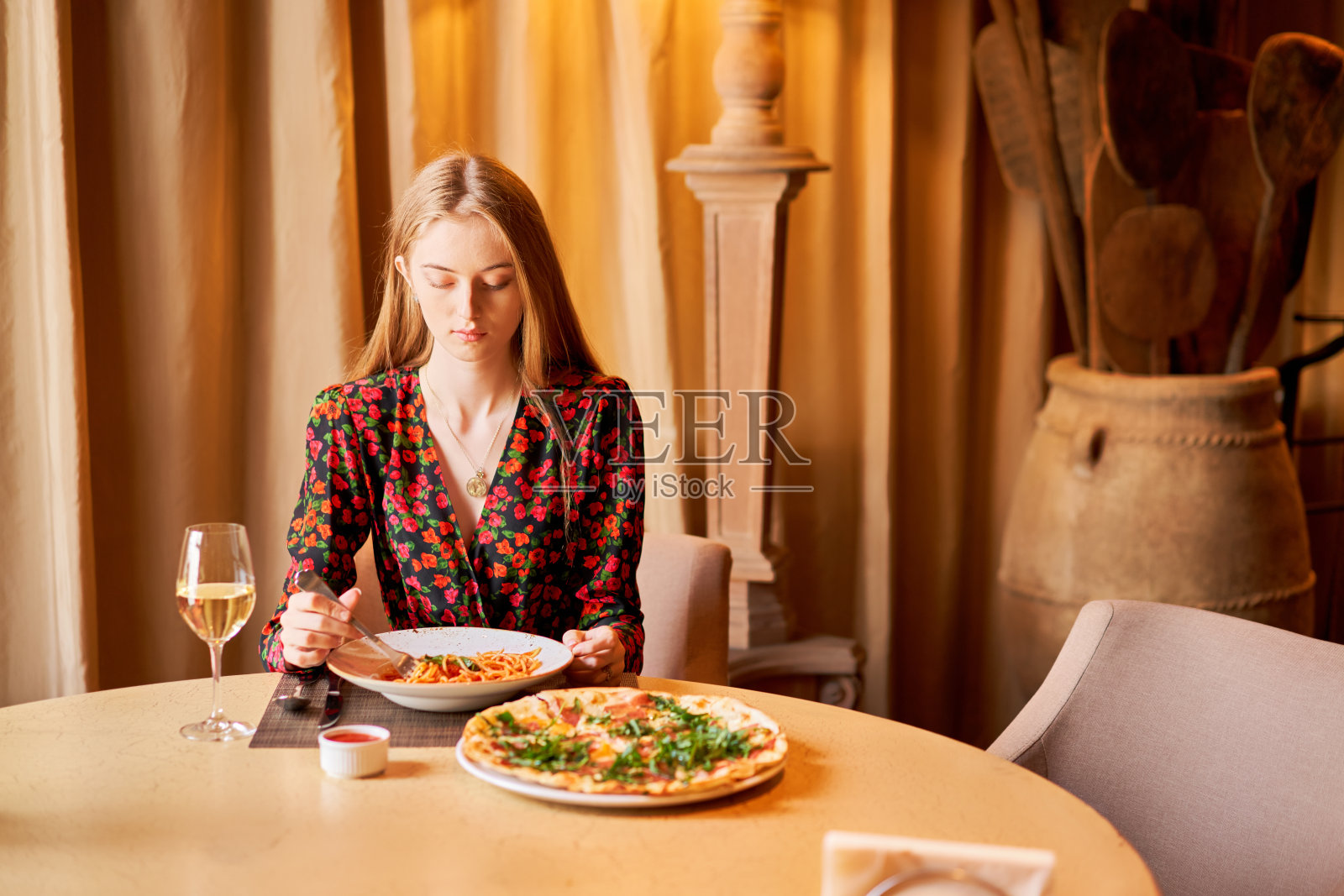 意大利饮食店。女人吃意大利面配番茄,肉。意大利肉酱面用勺子绕在叉子上。帕玛森芝士照片摄影图片