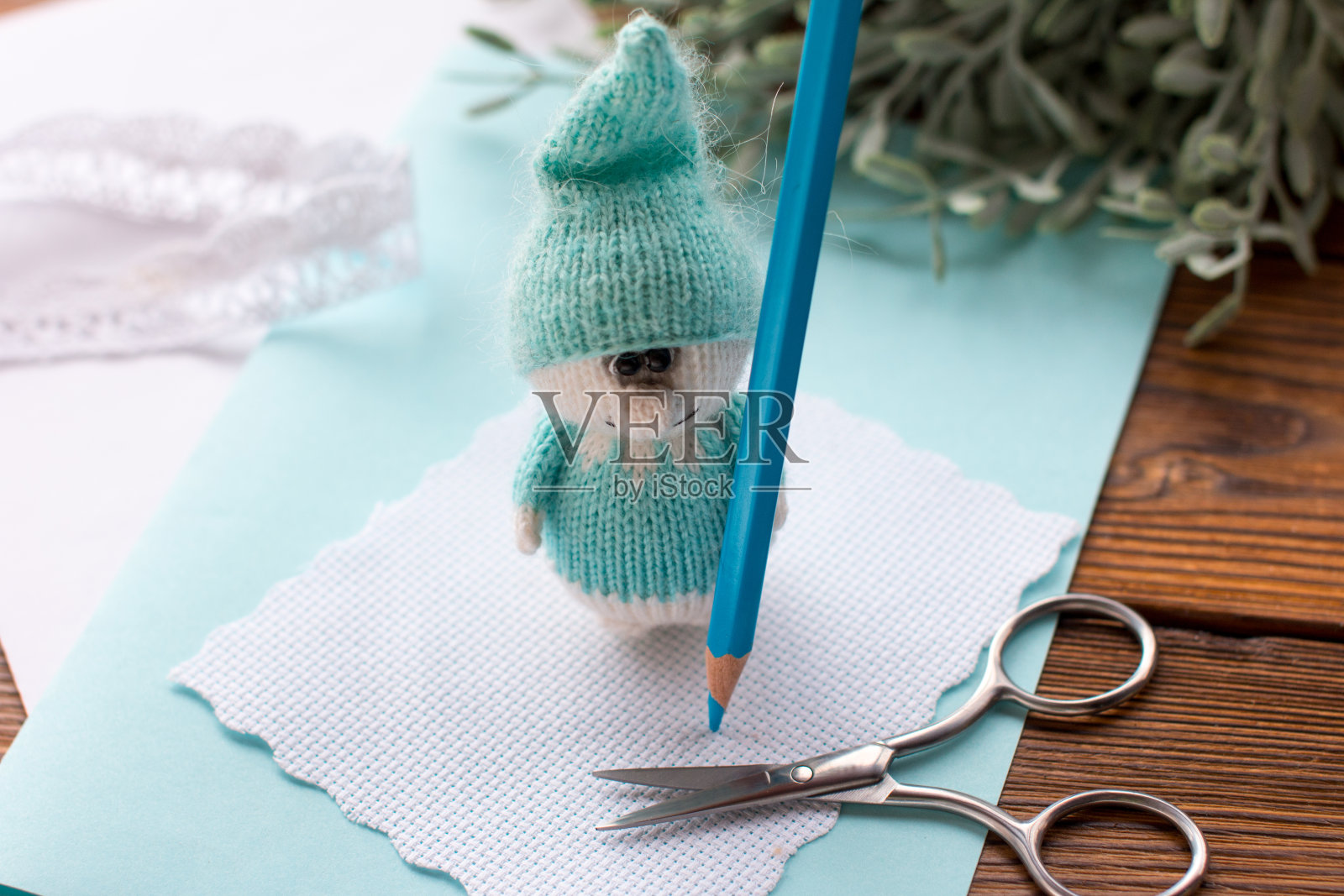 一个编织的蓝矮人拿着一支铅笔。手工制作,手工制作照片摄影图片