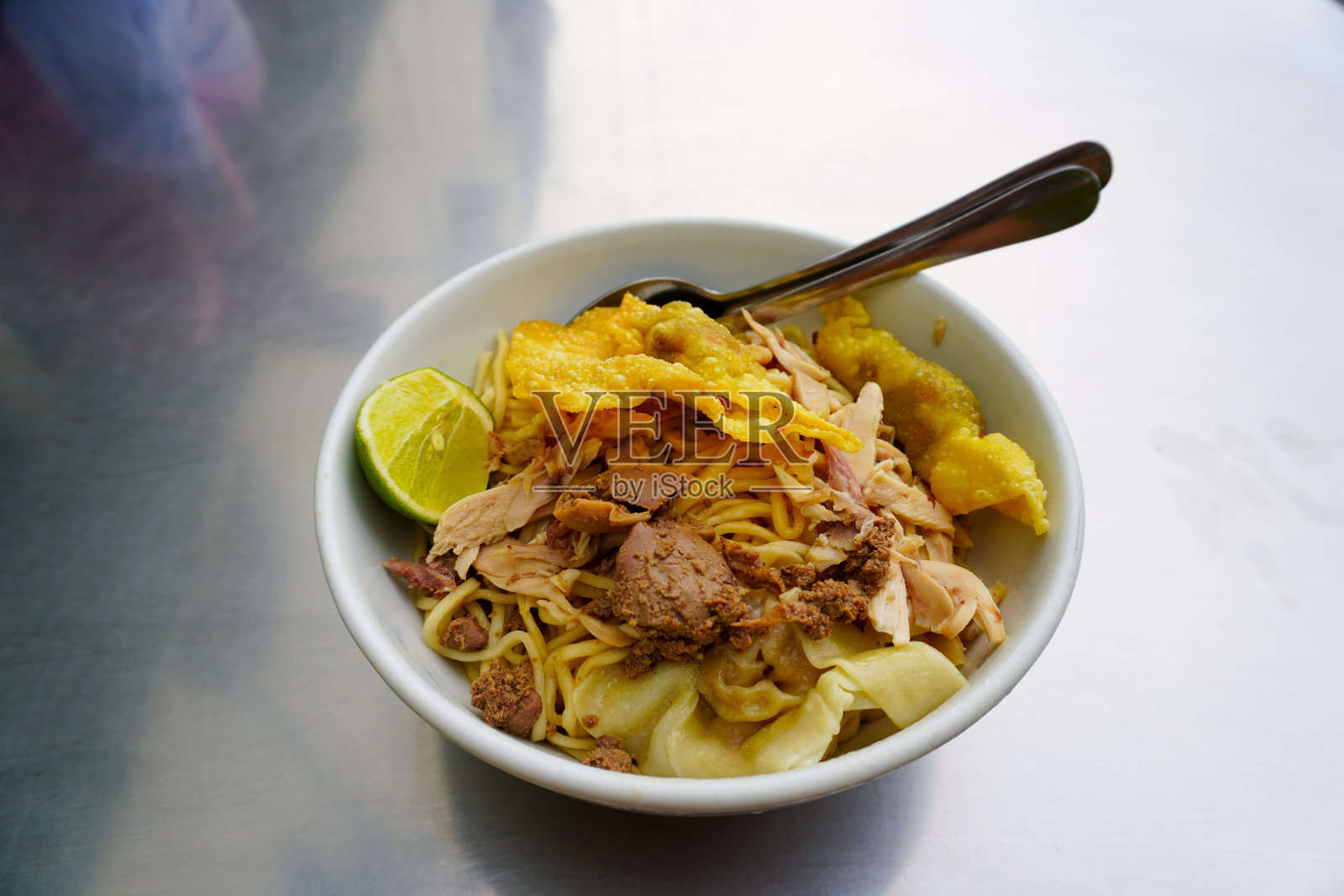 米氏Ayam。印尼当地食物鸡肉面和肉汁分装在不同的碗里照片摄影图片