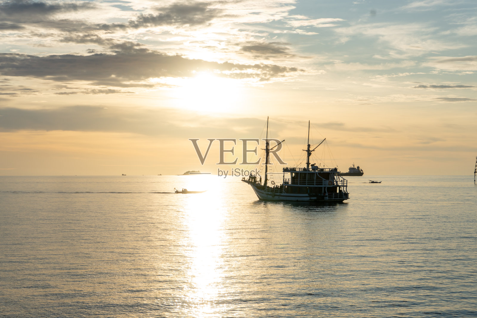 令人惊叹的帆船在橙色日落剪影。美丽的橙色日落与帆船剪影照片摄影图片