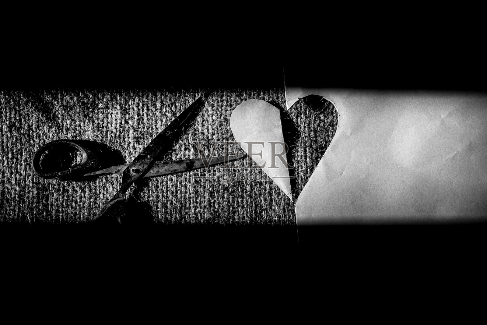 剪刀剪心形的纸,用剪刀把纸剪成心形或爱情的形状照片摄影图片