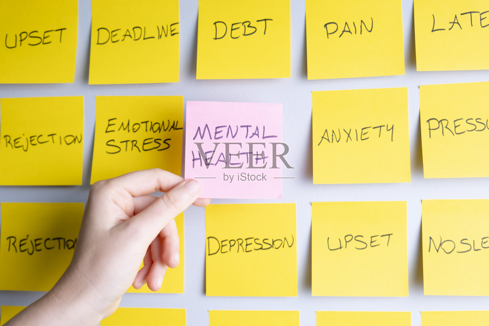 女人拿着贴在墙上的心理健康便利贴照片摄影图片