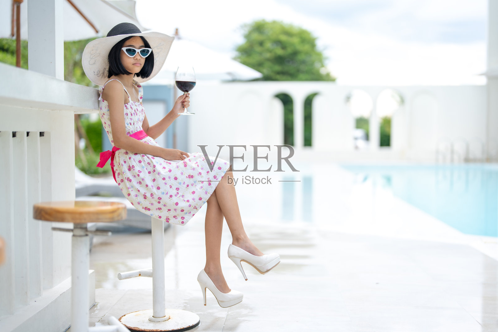 在酒店,这位年轻的亚洲游客受到了工作人员的热情欢迎,他们确保她的假期充满舒适和放松,并在她到达酒店大厅时为她提供了一杯葡萄酒。照片摄影图片