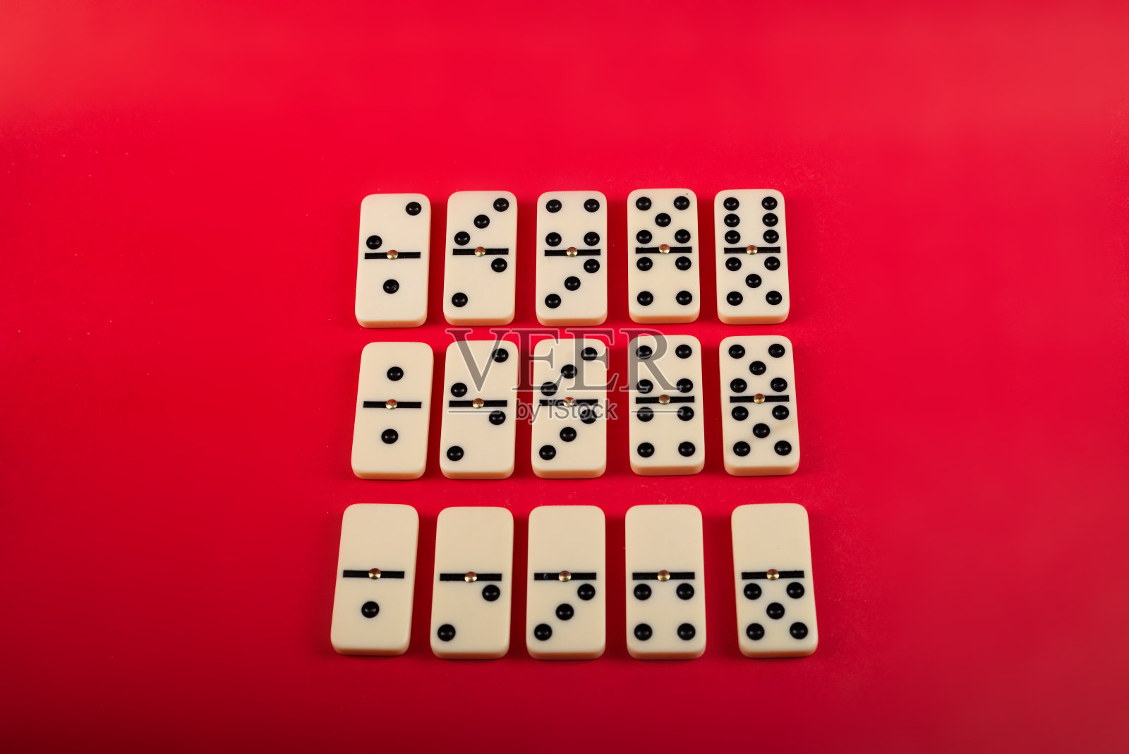红色背景的多米诺骨牌。照片摄影图片