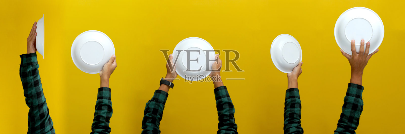 手捧空白色盘子孤立在一个黄色的背景照片摄影图片