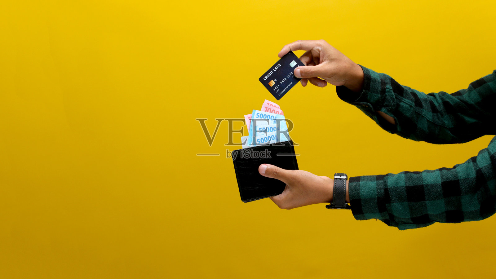 男子从钱包里拿出信用卡进行网上购物照片摄影图片